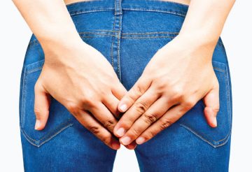 woman holding buttocks