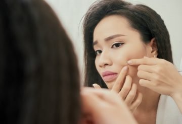 woman checking on pimple