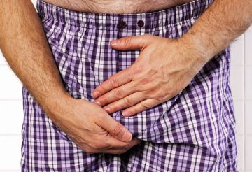 man holding his crotch